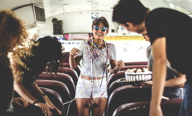 A young woman having a birthday party on a bus.
