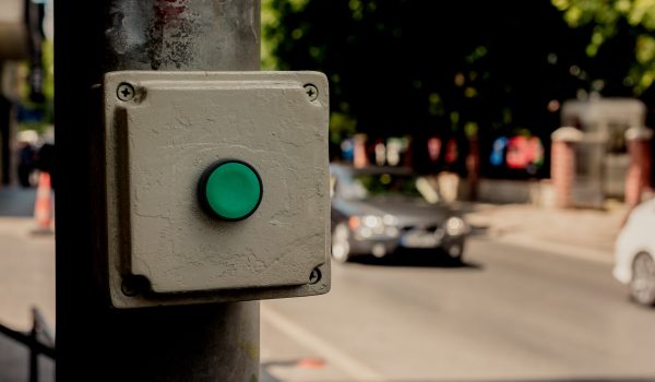 Closeup shot of a green button on a tube on the street