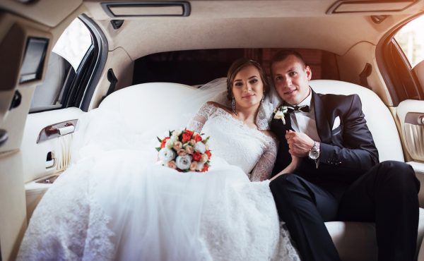 young couple in a car in wedding day